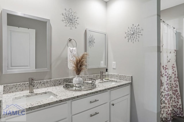 full bathroom with double vanity and a sink