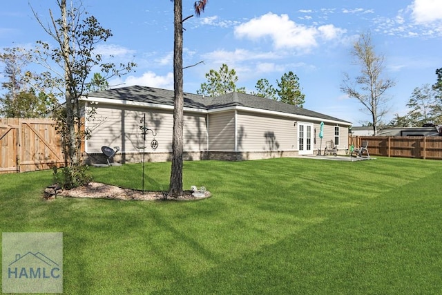 rear view of house featuring french doors, a yard, a fenced backyard, and a patio area