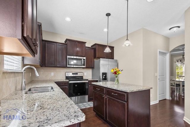 557 Archie Way NE, Ludowici, GA 31316 - kitchen with appliances with stainless steel finishes, a sink, tasteful backsplash, dark brown cabinetry, and dark wood-style floors