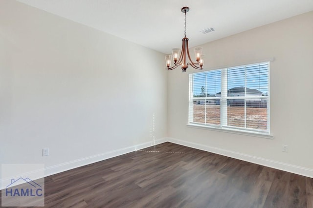 unfurnished room with an inviting chandelier and dark hardwood / wood-style flooring