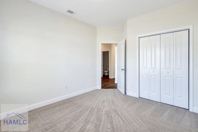 unfurnished bedroom featuring dark carpet and a closet