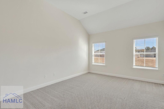 spare room with vaulted ceiling and carpet