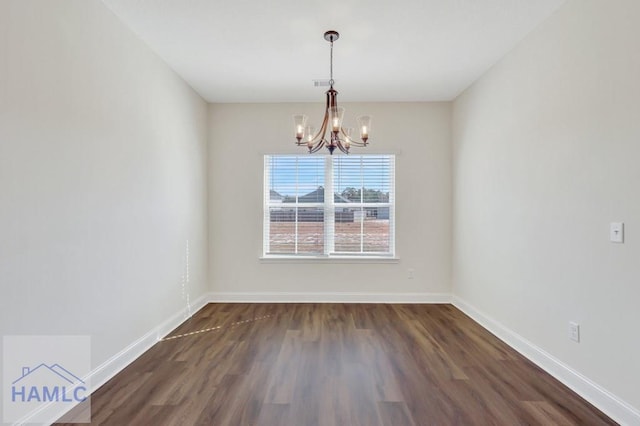 unfurnished dining area featuring dark hardwood / wood-style flooring and a notable chandelier