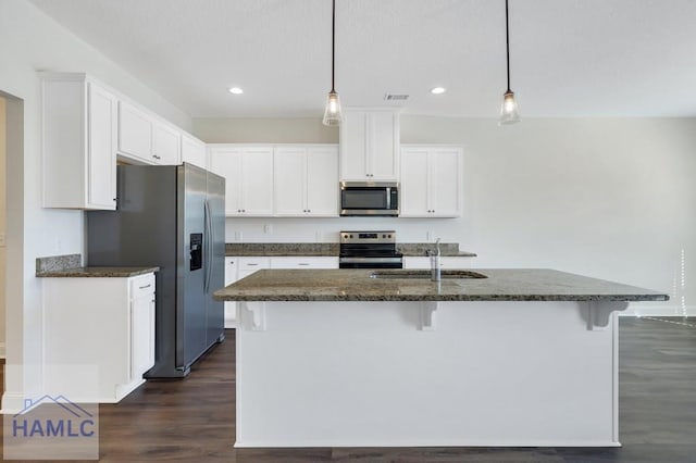 kitchen with white cabinetry, sink, stainless steel appliances, and a center island with sink