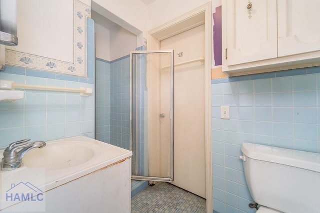 153 Drennon Dr, Jesup, GA 31545 - bathroom featuring tile walls, a shower stall, toilet, a wainscoted wall, and vanity