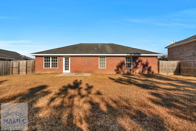 rear view of house with a patio and a lawn