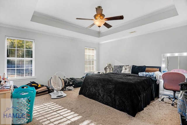 carpeted bedroom featuring ceiling fan, a tray ceiling, and ornamental molding