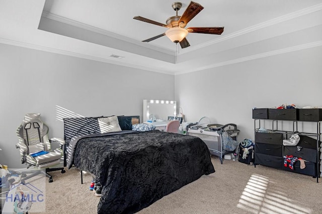 bedroom with ceiling fan, ornamental molding, carpet flooring, and a tray ceiling