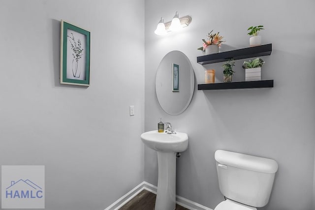 26 Sunflower Cir, Ludowici, GA 31316 - bathroom featuring toilet, baseboards, wood finished floors, and a sink