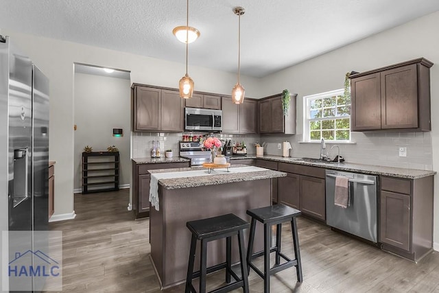 26 Sunflower Cir, Ludowici, GA 31316 - kitchen featuring appliances with stainless steel finishes, a sink, light wood-type flooring, a center island, and dark brown cabinetry