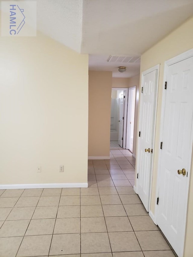 hall featuring light tile patterned floors