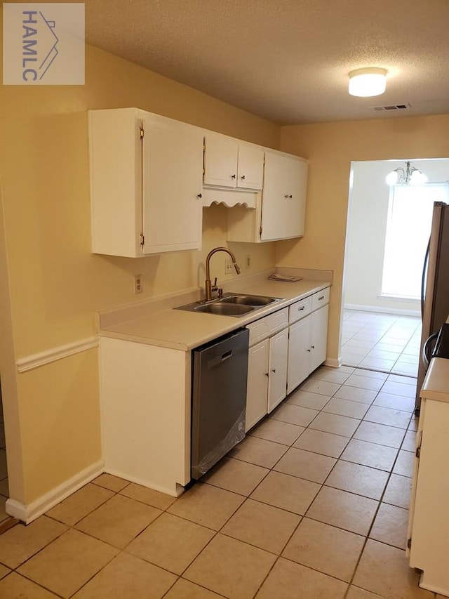 kitchen with a textured ceiling, sink, light tile patterned floors, dishwasher, and white cabinetry