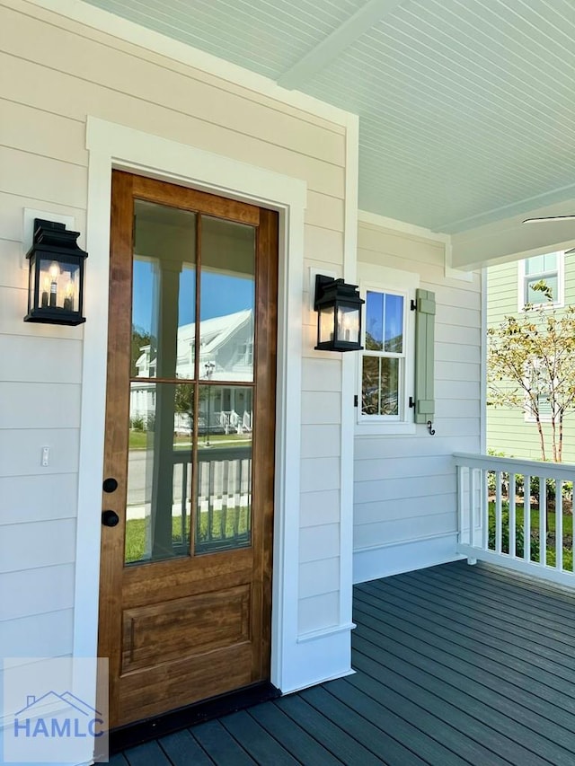 view of exterior entry featuring covered porch