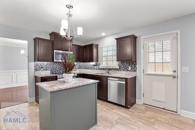 42 Kinlock Ct, Midway, GA 31320 - kitchen featuring appliances with stainless steel finishes, a chandelier, dark brown cabinetry, tasteful backsplash, and a kitchen island