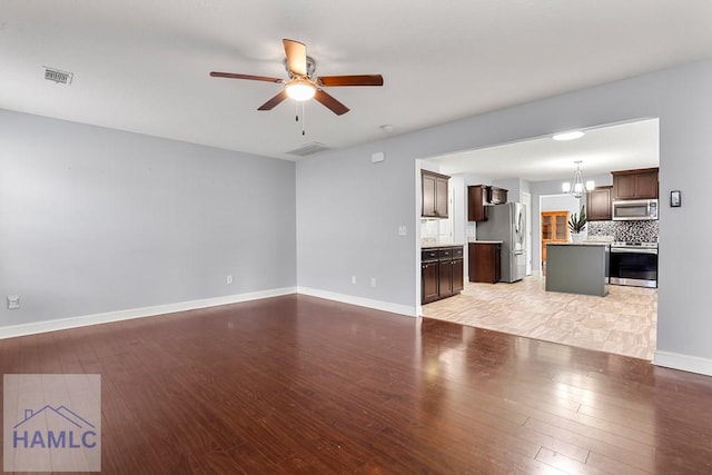 42 Kinlock Ct, Midway, GA 31320 - unfurnished living room with light wood-style flooring, a ceiling fan, and a chandelier