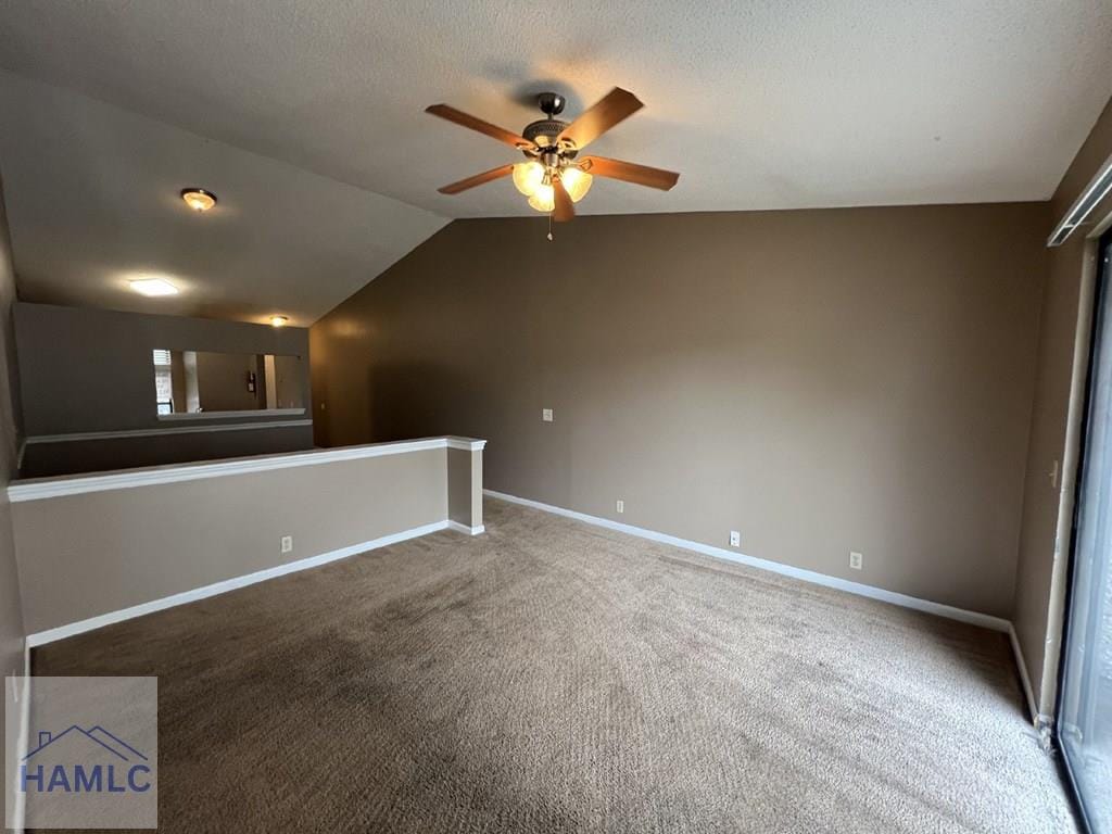 unfurnished room featuring ceiling fan, lofted ceiling, and carpet floors