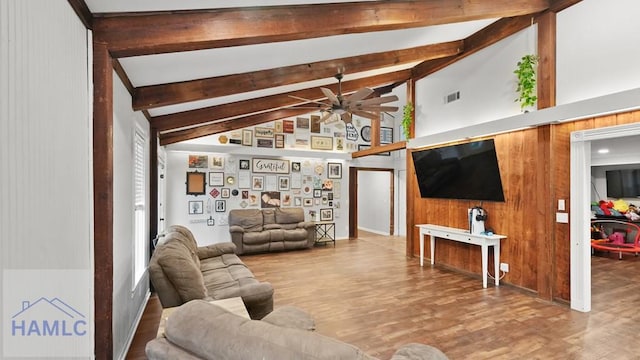 living room featuring ceiling fan, wooden walls, lofted ceiling with beams, and hardwood / wood-style floors