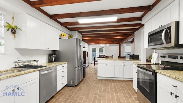 kitchen with white cabinetry, light stone counters, appliances with stainless steel finishes, kitchen peninsula, and beamed ceiling