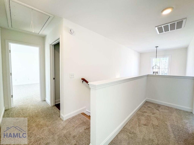 hallway featuring light colored carpet