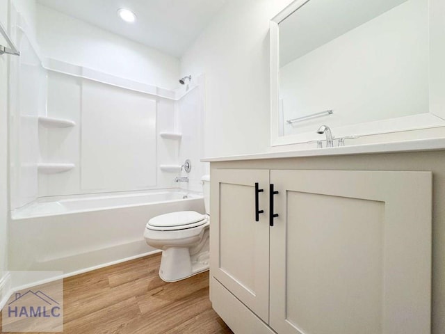 full bathroom featuring hardwood / wood-style flooring, vanity, toilet, and tub / shower combination