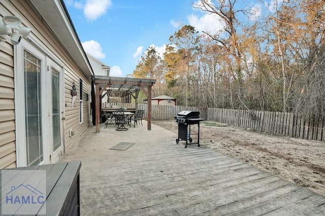 deck with outdoor dining area, a grill, a fenced backyard, and a pergola