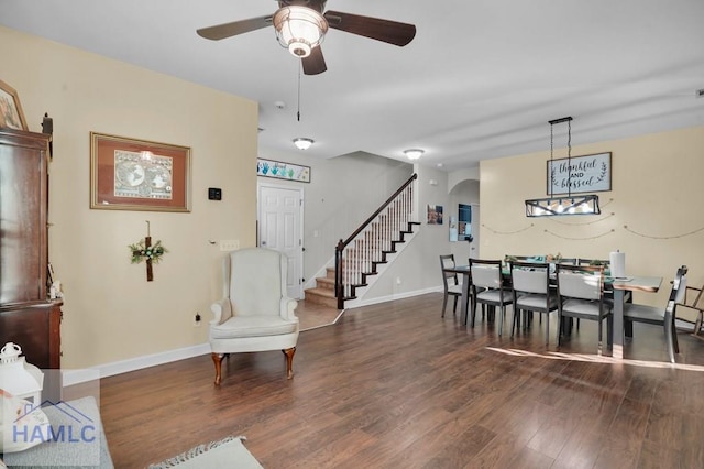 dining area with arched walkways, stairway, ceiling fan, and wood finished floors