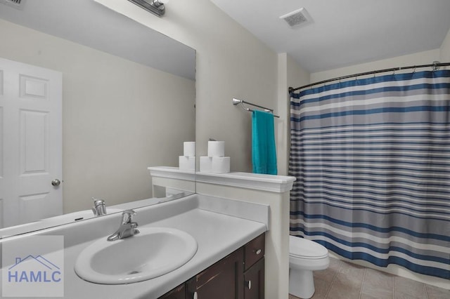 bathroom with tile patterned flooring, toilet, vanity, and visible vents