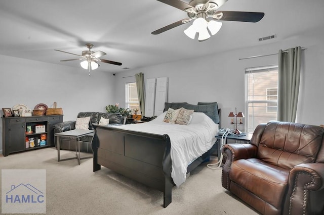 bedroom with visible vents, light colored carpet, and ceiling fan