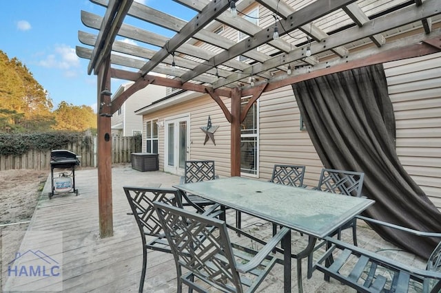 wooden terrace with outdoor dining space, a pergola, and fence