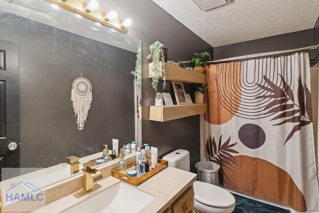 bathroom with vanity, a textured ceiling, and toilet