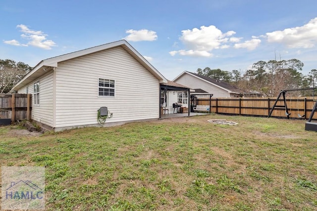 back of house with a lawn and a patio area