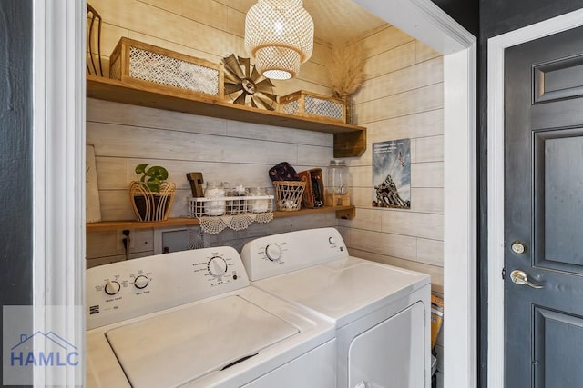 laundry area featuring separate washer and dryer and wooden walls