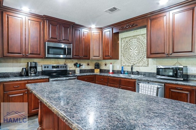 195 Linden Dr, Jesup, GA 31545 - kitchen featuring backsplash, a sink, visible vents, stainless steel appliances, and dark countertops