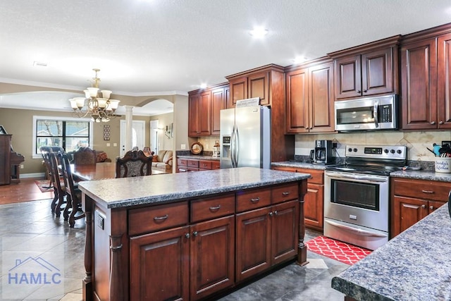 195 Linden Dr, Jesup, GA 31545 - kitchen featuring ornate columns, stainless steel appliances, decorative backsplash, arched walkways, and a notable chandelier