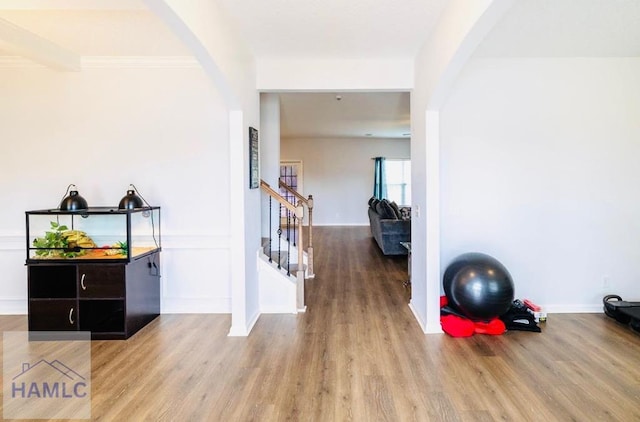 hallway with crown molding and light hardwood / wood-style flooring