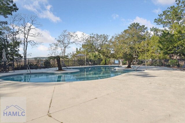 community pool featuring fence and a patio