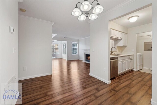 kitchen with crown molding, light countertops, a sink, a chandelier, and dishwasher