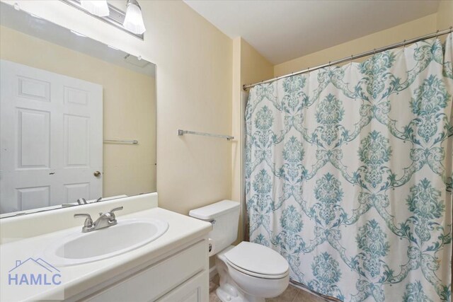 bathroom with a shower with curtain, toilet, vanity, and tile patterned floors