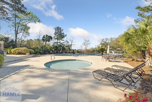 community pool with a patio and a community hot tub