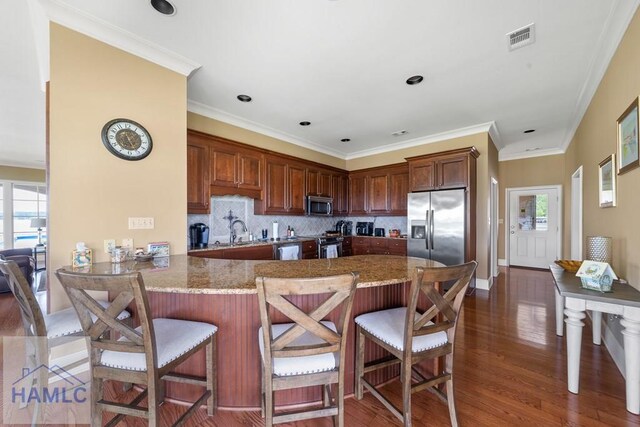 745 Chickasaw Trl, Sparta, GA 31087 - kitchen with stainless steel appliances, wood finished floors, plenty of natural light, and ornamental molding