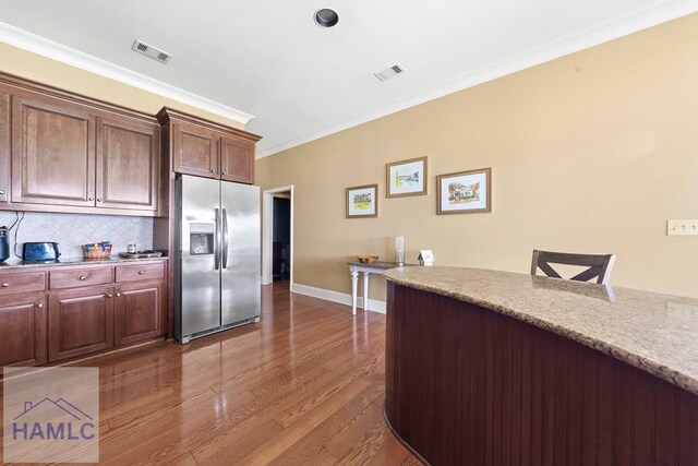 745 Chickasaw Trl, Sparta, GA 31087 - kitchen with stainless steel fridge, crown molding, wood finished floors, decorative backsplash, and baseboards