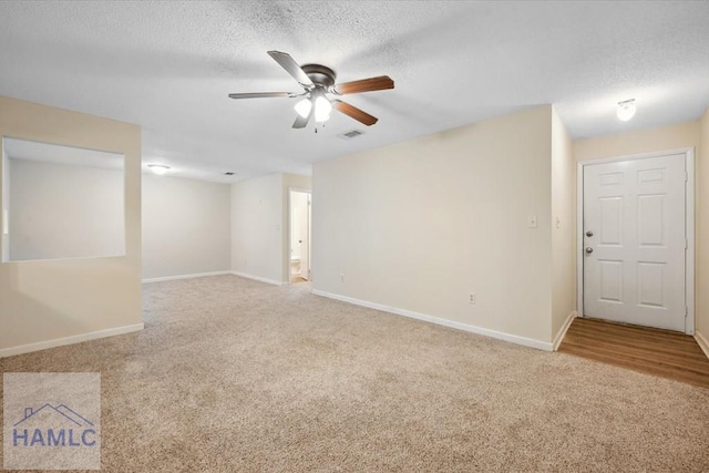 spare room featuring visible vents, ceiling fan, a textured ceiling, and carpet