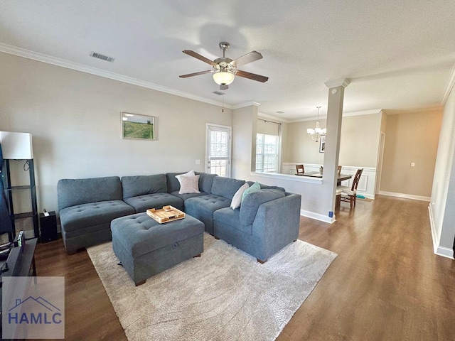 living room with hardwood / wood-style flooring, crown molding, and ceiling fan with notable chandelier