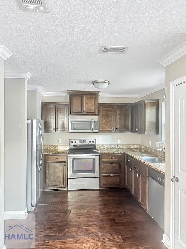 kitchen featuring dark hardwood / wood-style floors, sink, light stone counters, stainless steel appliances, and dark brown cabinets