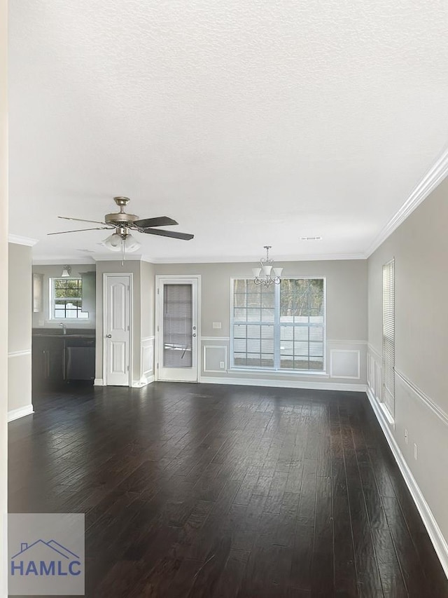 unfurnished living room with crown molding, dark wood-type flooring, a textured ceiling, and ceiling fan with notable chandelier