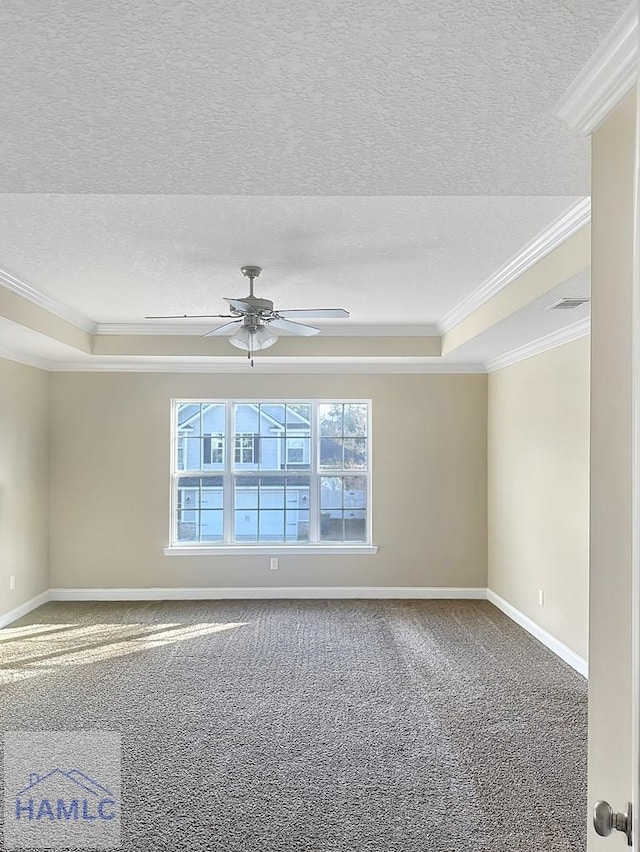 carpeted empty room featuring ornamental molding, a textured ceiling, ceiling fan, and a tray ceiling