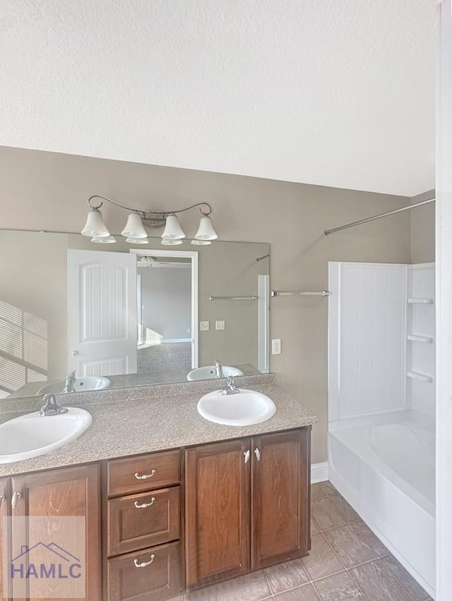 bathroom featuring tile patterned floors, vanity, bathtub / shower combination, and a textured ceiling