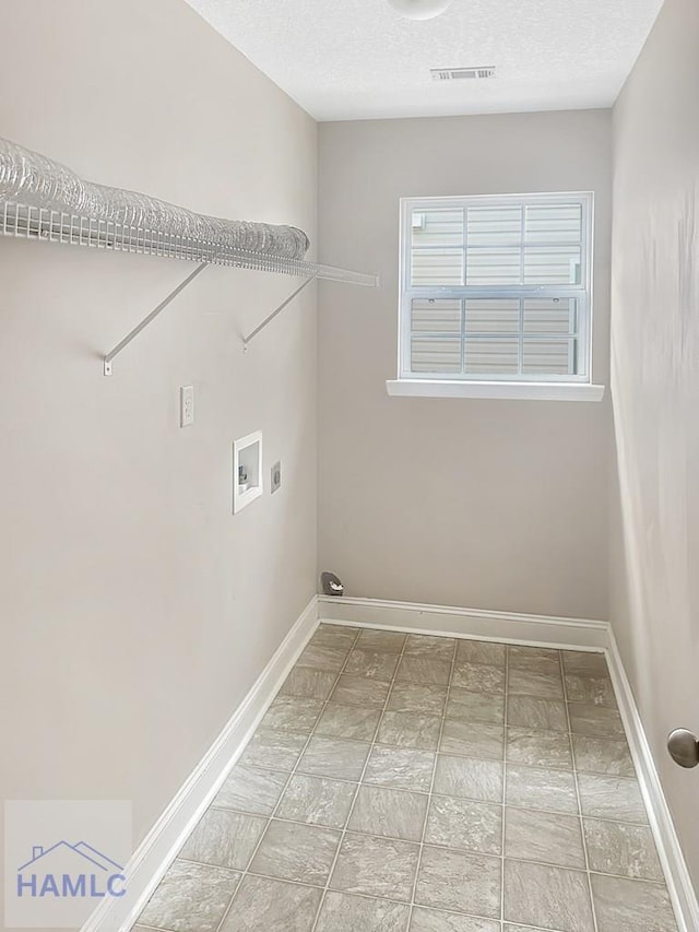 washroom with washer hookup and a textured ceiling