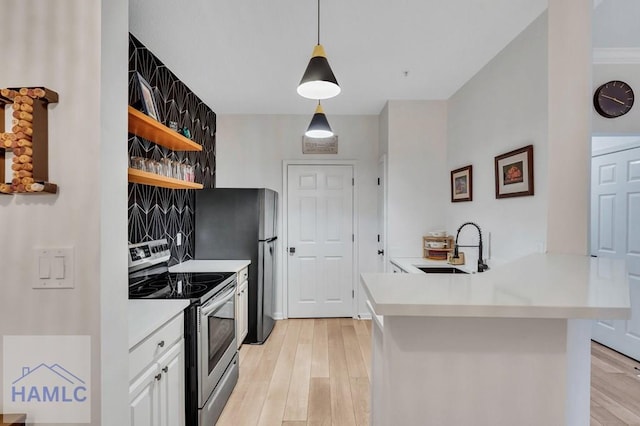 kitchen with appliances with stainless steel finishes, sink, white cabinets, hanging light fixtures, and kitchen peninsula