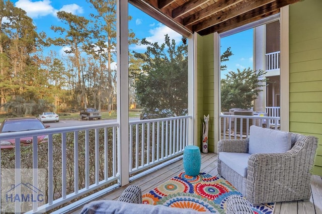 unfurnished sunroom featuring wooden ceiling and beamed ceiling